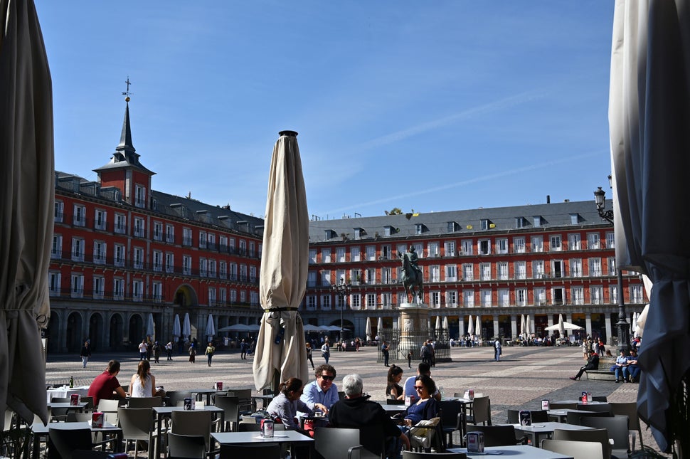 People sit at a terrace at Madrid's Plaza Mayor on March 13 as the city's mayor announced that he would order the closure of 