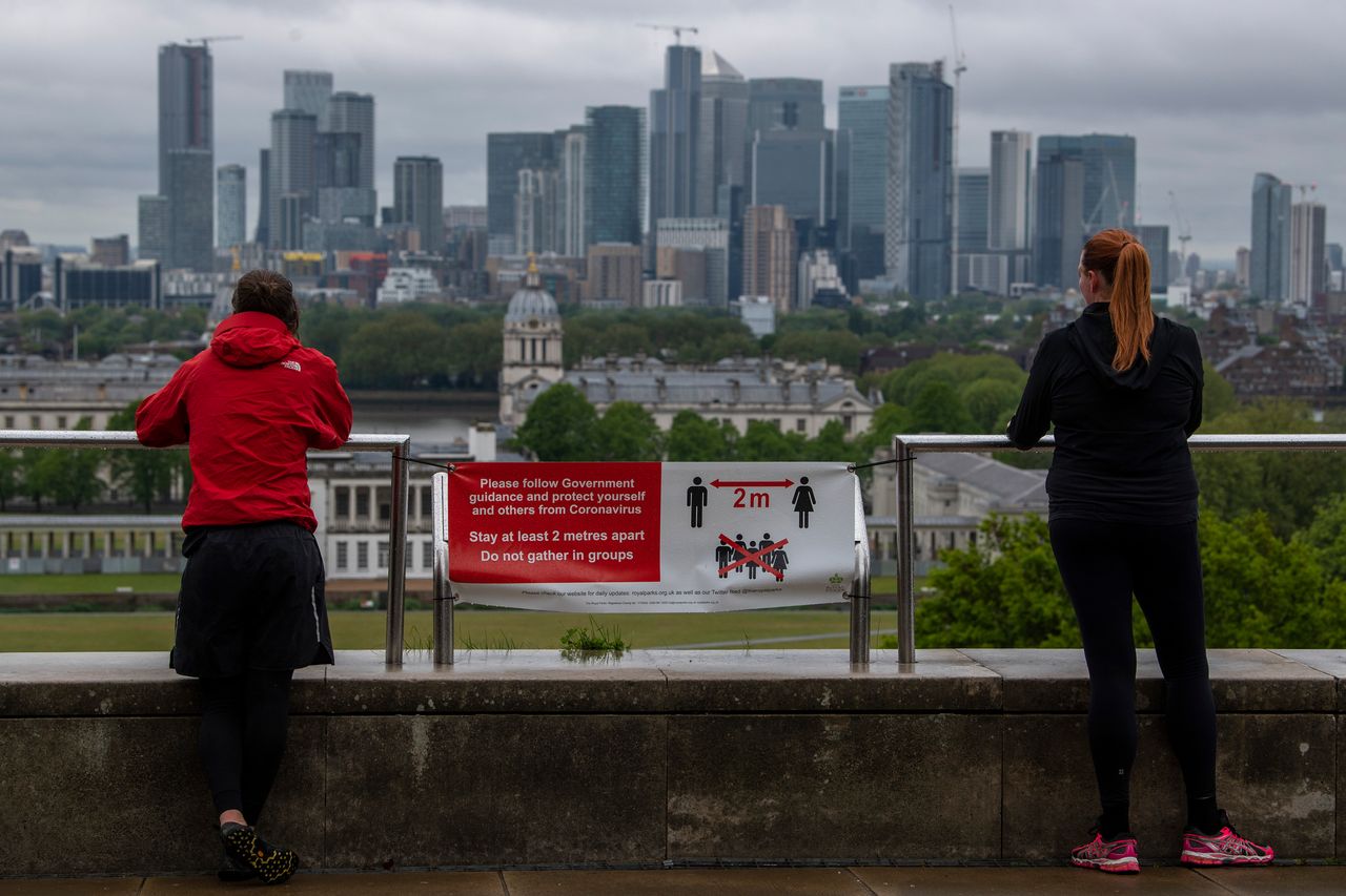 Joggers stop to look at the London skyline from Greenwich Park on April 28. Social distancing measures are likely to become a standard part of life for the foreseeable future.