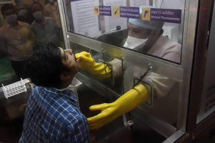 An instructor collects swab samples from a person during an inauguration of Smart Covid-19 OPD at JJ Hospital in Mumbai, India on April 30, 2020. 