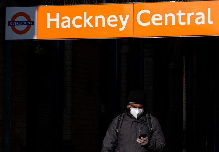 A man in a face mask leaves Hackney Central station