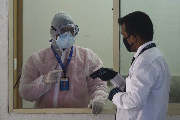 A man wearing a protective suit stands in a waiting room used for people to be tested for the COVID-19...