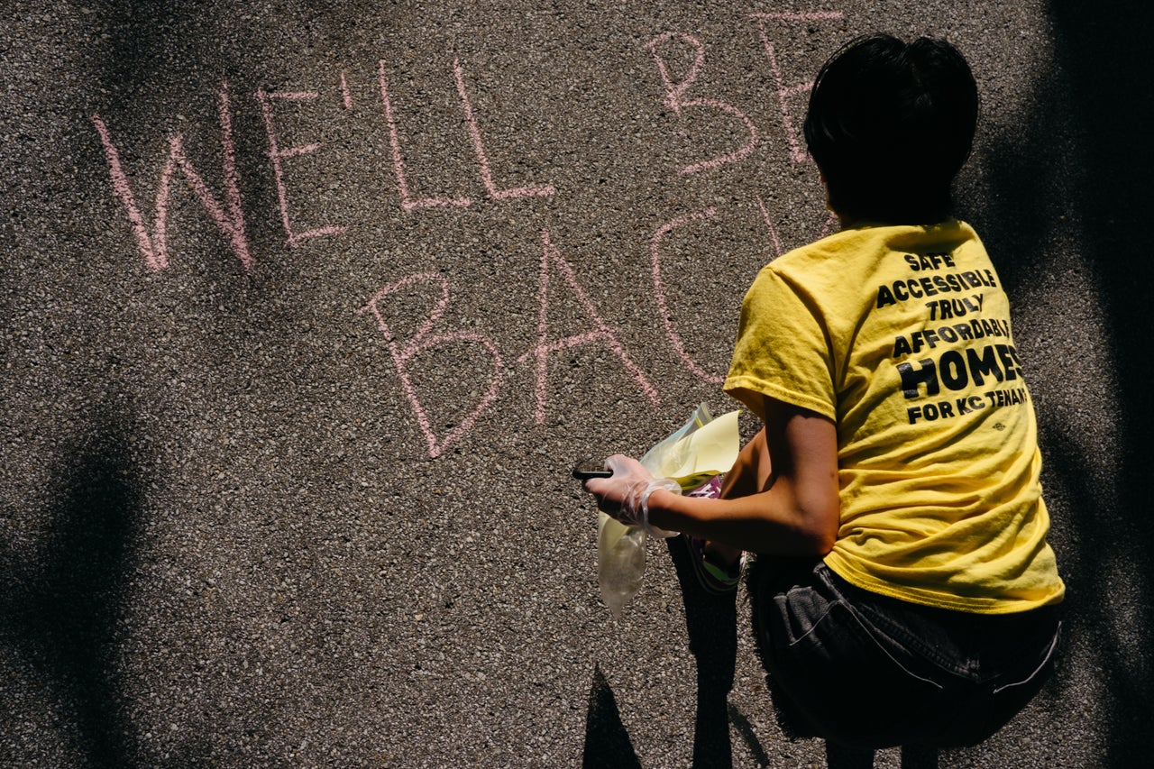 Protesters write notes to Missouri Gov. Mike Parson in the street in front of the Governor's Mansion in Jefferson City.