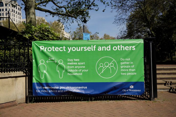 A coronavirus guidelines banner is displayed by an entrance to Victoria Embankment Gardens in London