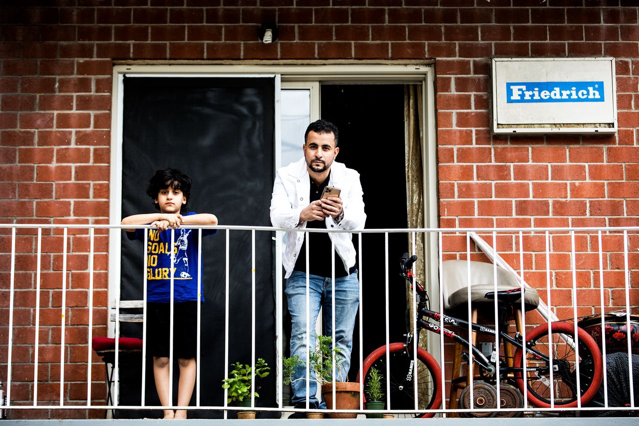 Abdullah, Emad Al-Azabi's cousin, stands with his nephew on the balcony of his home in Queens, New York City, in April. 