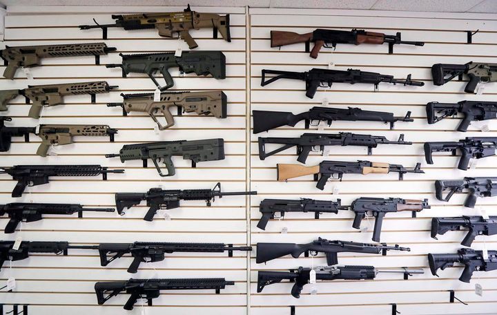 Semi-automatic rifles fill a wall at a gun shop in Lynnwood, Wash. on Oct. 2, 2018.
