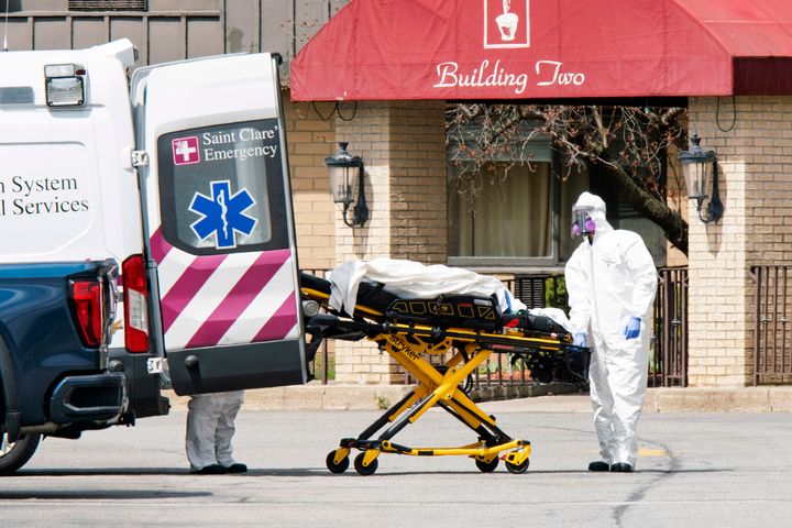 Medical workers load a deceased body into an ambulance outside a New Jersey nursing home.