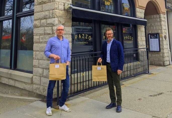 Jeff Leney (left) and Larry McCabe pose in front of Pazzo's Taverna & Pizzeria, the restaurant they run in Stratford, Ont.