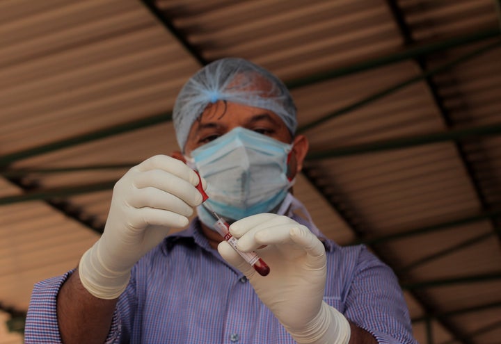 Health department officials collects blood samples for testing at a temporary COVID-19 rapid test center in between the lockdown days in the eastern Indian state odisha's capital city Bhubaneswar on April 20, 2020. (Photo by STR/NurPhoto via Getty Images)