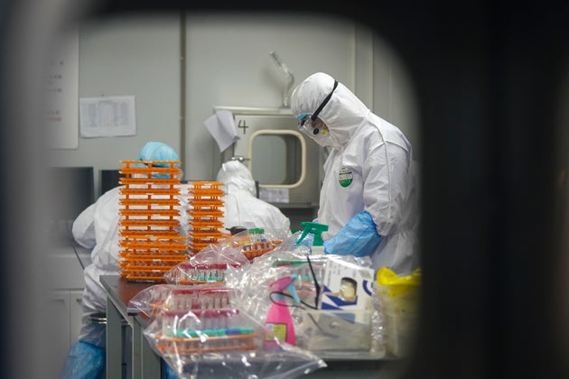 Photo shows medical workers in protective suits at a coronavirus detection lab in Wuhan in central China's Hubei Province. (Cheng Min/Xinhua via AP)