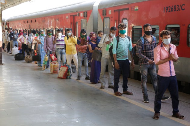 Migrant workers stand in a queue to board a special train to return to Agra in Uttar Pradesh on Saturday,...