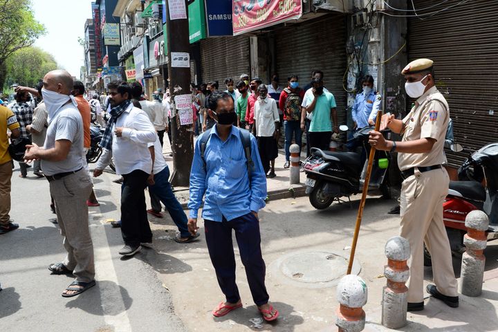 Police disperse people lining up to buy alcohol near a liquor shop in New Delhi on May 4, 2020. 