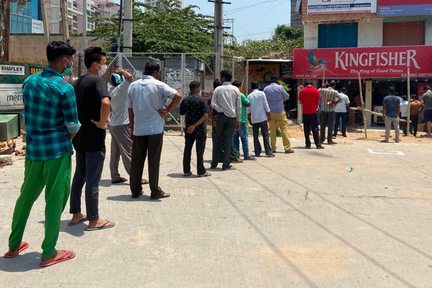 People queue at a liquor store in Bangalore on May 4,