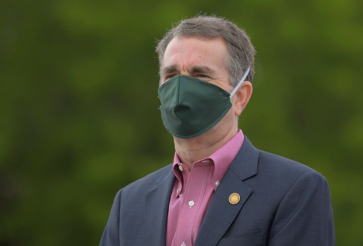 Virginia Gov. Ralph Northam, wearing a mask, watches as a coronavirus testing site is set up in Richmond on April 28, 2020. Northam has issued executive orders that ban in-person religious services of over 10 people.