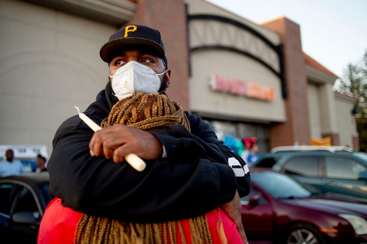 Calvin Munerlyn's cousin Pete Tedford embraces Munerlyn's sister Dorothy Nelson outside the Family Dollar store on Sunday.