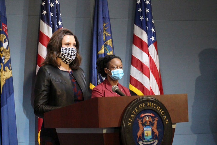 Michigan Governor Gretchen Whitmer, left, wears a mask while addressing the state on Friday.