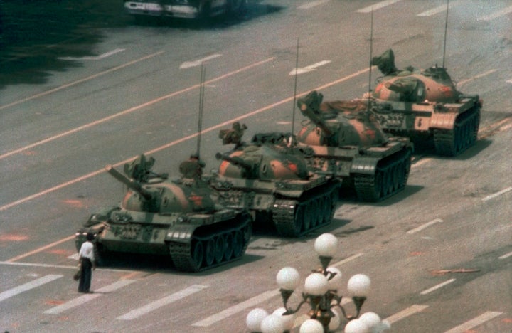 In this June 5, 1989, file photo, a Chinese man stands alone to block a line of tanks heading east on Beijing's Changan Boulevard in Tiananmen Square. The man, calling for an end to the recent violence and bloodshed against pro-democracy demonstrators, was pulled away by bystanders, and the tanks continued on their way. (AP Photo/Jeff Widener, File)