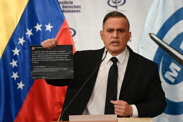 Venezuela's Attorney General Tarek William Saab holds up Twitter posts during a press conference regarding what the governmen