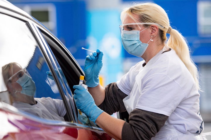 A person is tested for coronavirus at the drive through facility at the Edgbaston Cricket Ground Covid-19 testing site in Birmingham, England