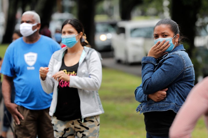 People line up for food at a food distribution point for people economically impacted by the coronavirus pandemic, organized by New Orleans City Councilman Jay Banks, in New Orleans, Wednesday, April 29, 2020. (AP Photo/Gerald Herbert)