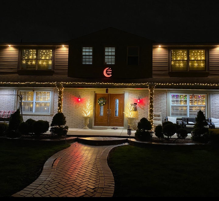 A color-changing crescent moon hangs outside a family's house as part of its Ramadan Lights contest submission.