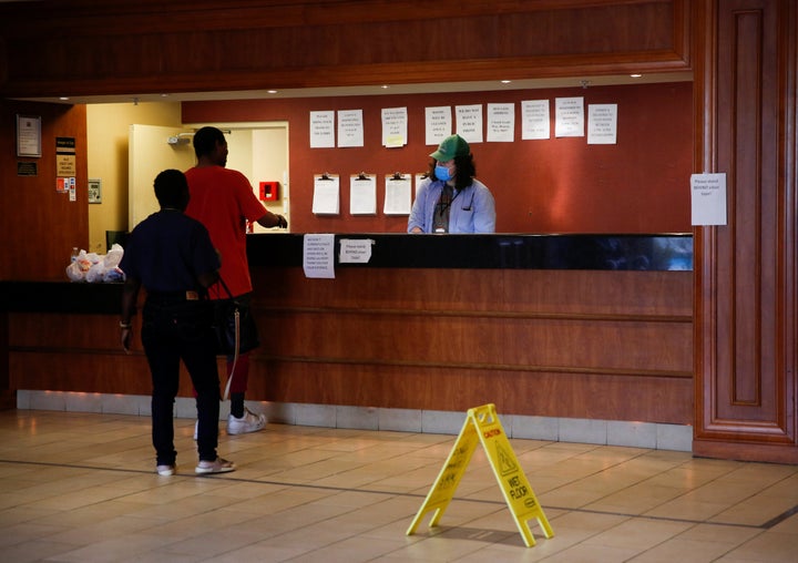 Clients talk with a staff member standing at the front desk at the Red Lion Hotel in Renton, Washington.