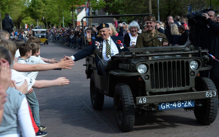 Children reach out to touch the hand of Canadian World War II navy veteran Bert Reynolds, 88, as he takes part in a parade to celebrate the 70th anniversary of the Liberation of the Netherlands in Wageningen, Netherlands on Tuesday, May 5, 2015. (Sean Kilpatrick/The Canadian Press via AP) MANDATORY CREDIT