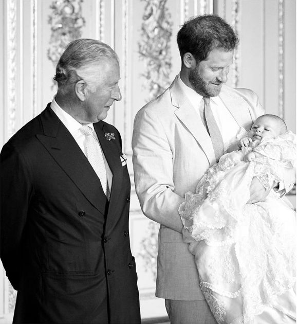 Prince Charles and Harry look at Archie on the day of his christening.