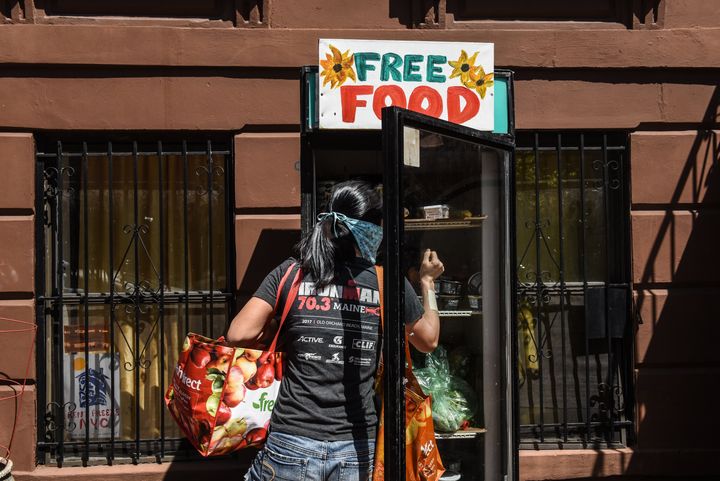Γυναίκα στο Μπρούκλιν της Νέας Υόρκης αναζητά τρόφιμα σε ψυγείο που διαθέτει δωρεάν προϊόντα για όσους έχουν ανάγκη (5 Μαϊου 2020) 