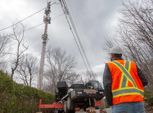 A cellphone tower is repaired by technicians in Piedmont, Que., after a fire was reported on