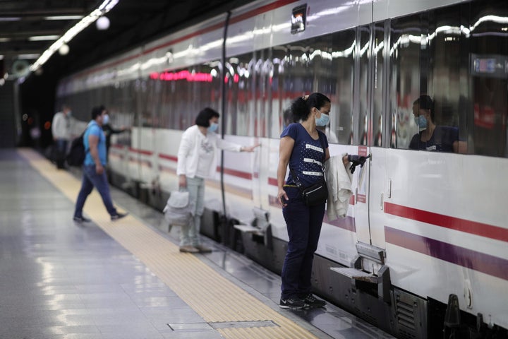 Un grupo de viajeros con mascarillas en la estación de tren de Cercanías de Nuevos Ministerios, en Madrid.