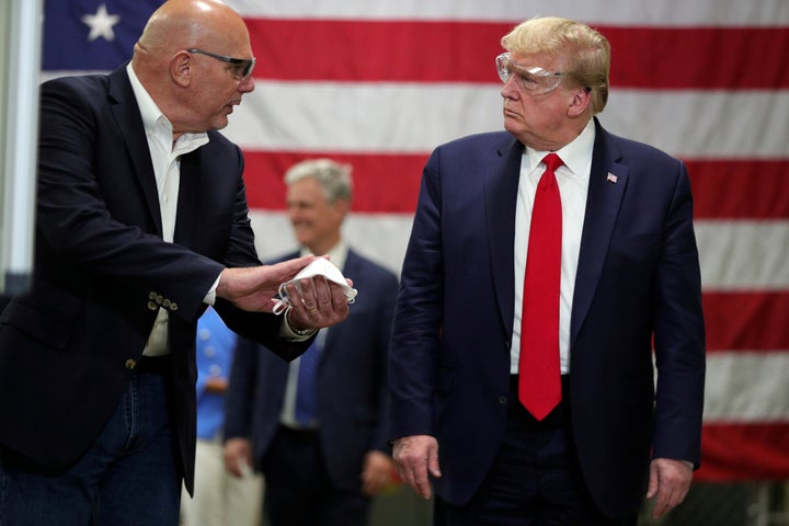 U.S. President Donald Trump listens to Honeywell's Vice President of Integrated Supply Chain Tony Stallings as Stallings shows him a protective mask during a tour of Honeywell's facility manufacturing face masks for the coronavirus disease (COVID-19) outbreak in Phoenix, Arizona, U.S., May 5, 2020