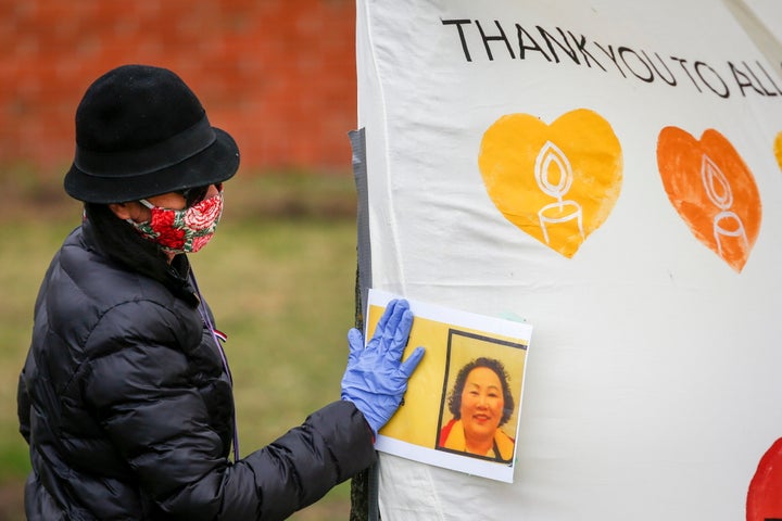 A mourner touches a photo at a May 4, 2020 memorial for Hiep Bui Nguyen, a Cargill worker who died from COVID-19.