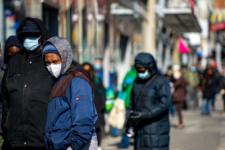 NEW YORK, NY - APRIL 16: People wait on line outside of TD Bank on April 16, 2020, in the Harlem neighborhood of New York Cit