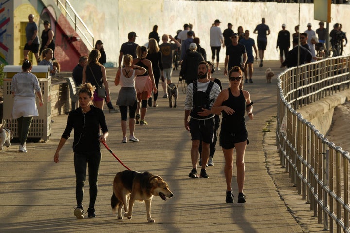 People walk and jog at the walk side of Bondi Beach after the beach reopens to surfers and swimmers after it was closed to curb the spread of the coronavirus disease (COVID-19), with strict social distancing measures remaining in place, in Sydney, Australia, April 28, 2020. REUTERS/Loren Elliott