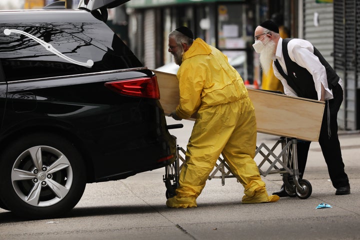 Orthodox Jewish men move a wooden casket on April 5, 2020, in the Borough Park neighborhood of Brooklyn, which has seen an upsurge of COVID-19 patients during the pandemic.