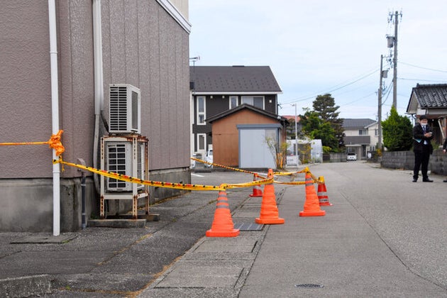 死亡したベトナム人技能実習生が住んでいたアパート(左側)。脇にある側溝に規制線が張られていた=2020年5月6日午後5時57分、富山市赤田、田添聖史撮影