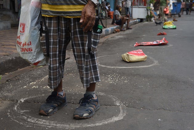Bags kept as placeholders in circles marking social distance in a queue to collect essential food grains...