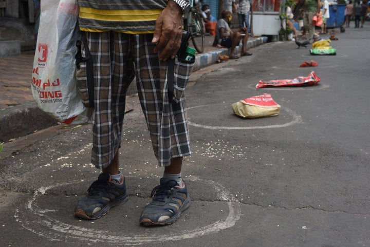 Bags kept as placeholders in circles marking social distance in a queue to collect essential food grains from a fair price shop in Entally on May 5, 2020 in Kolkata, India. 