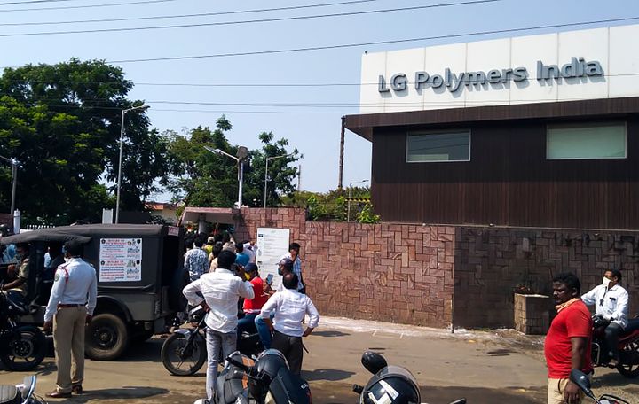 Policemen stand guard as people gather in front of an LG Polymers plant following a gas leak incident in Visakhapatnam on May 7, 2020.