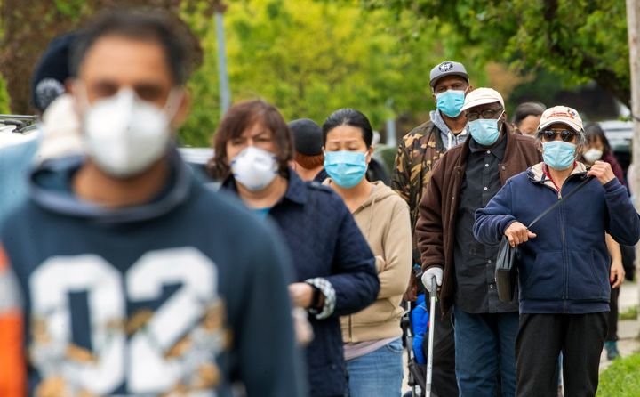 Residents of the Kew Gardens Hills neighborhood of the Queens borough of New York line up for free face masks, Tues. May 5, 2020.
