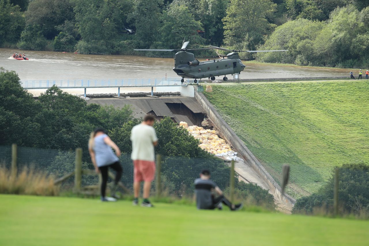 An RAF Chinook helicopter flies in sandbags to help repair the dam at Toddbrook reservoir near the village of Whaley Bridge in Derbyshire last year.