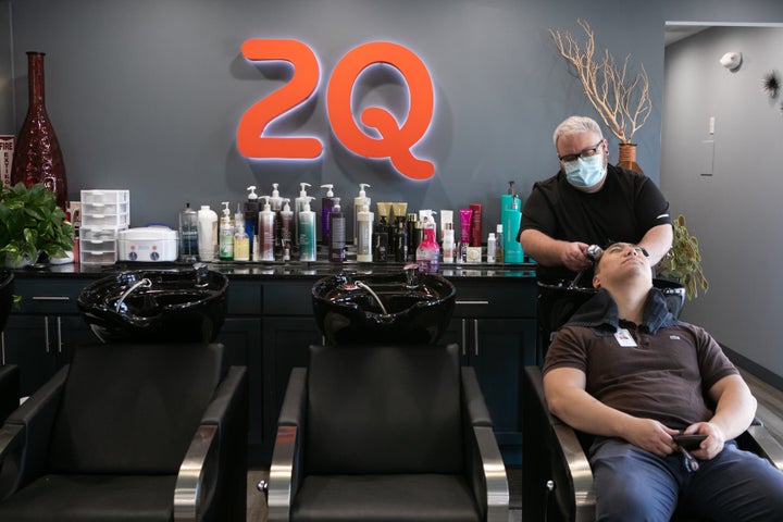 Harris Little washes Matt Kim's hair at 2Qute Hair Salon on April 27, 2020, in Atlanta. Georgia Gov. Brian Kemp has allowed some nonessential businesses to reopen, including restaurants, movie theaters, tattoo shops, gyms, and nail and hair salons.