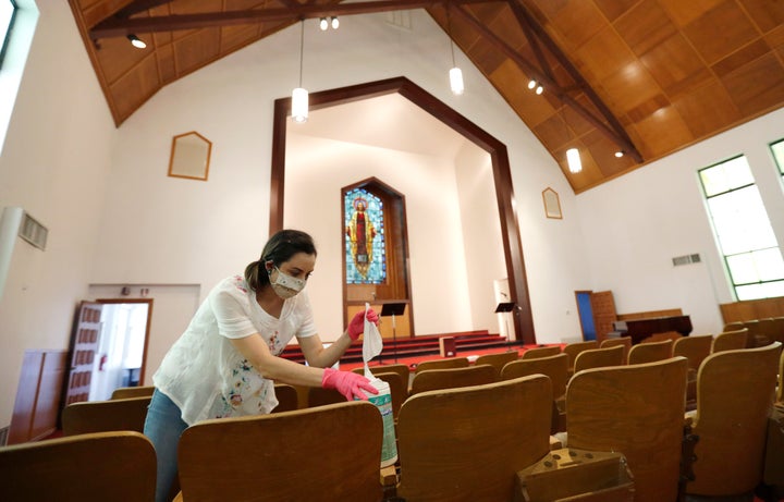 Hannah Contreras helps to clean, sanitize and prepare Alamo Heights Baptist Church for services this Sunday, in San Antonio, May 6. In a new HuffPost/YouGov poll, support for state stay-at-home orders has fallen from its peak, but remains high. (AP Photo/Eric Gay)