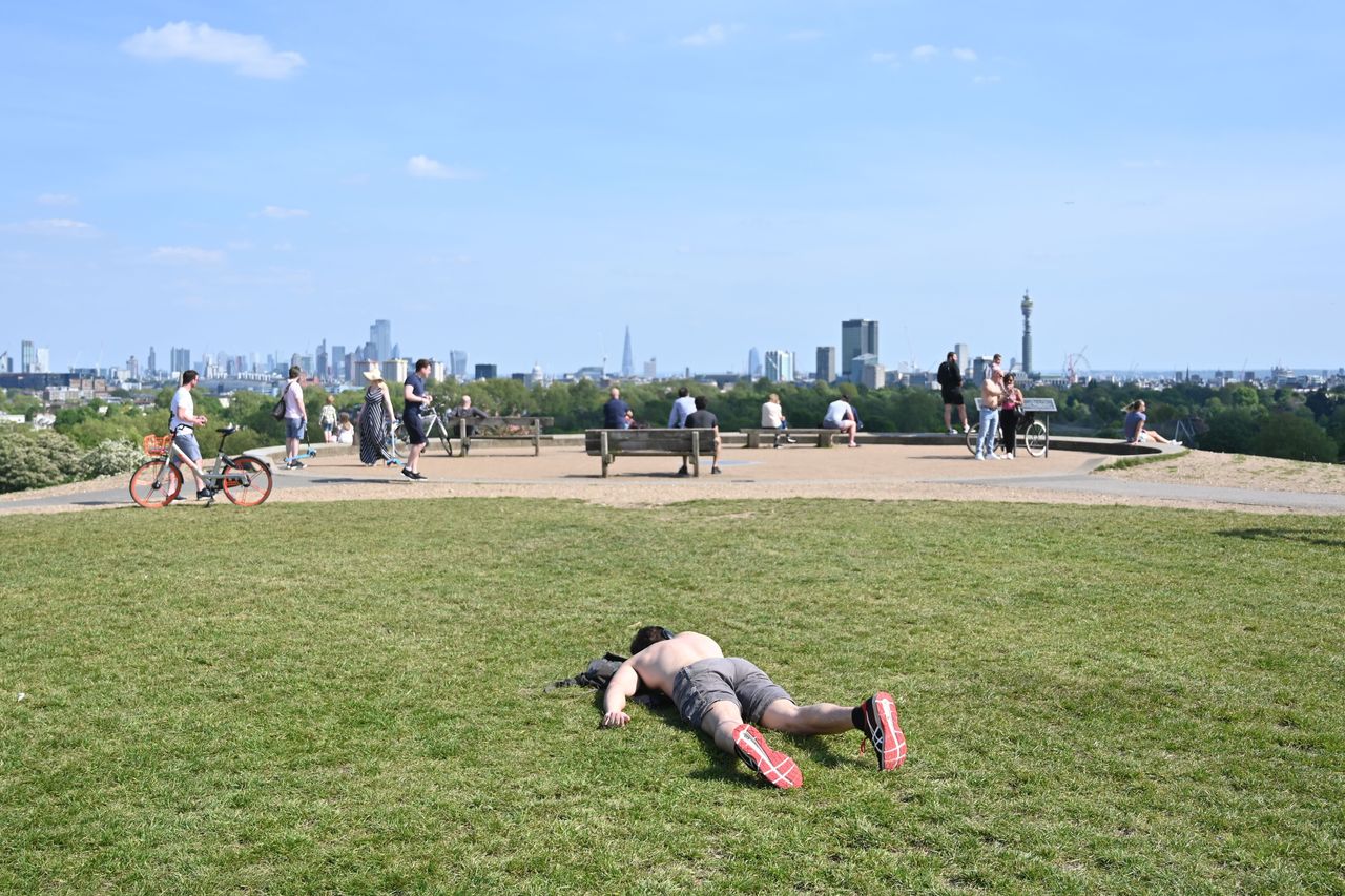 A man sunbathes on Primrose Hill in London during lockdown 