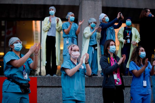 최전선에서 코로나19와 싸우는 이들을 응원하기 위한 행사를 지켜보던 의료진들이 박수를 치고 있다. 토론토, 온타리오주, 캐나다. 2020년