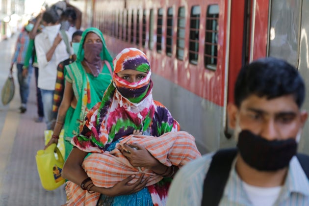Migrant workers stand to board a special train to return to Agra, Uttar Pradesh, during a nationwide...