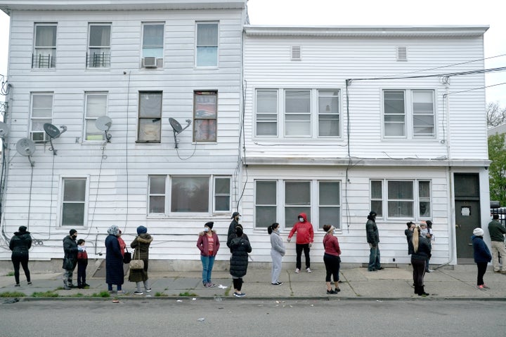 People wait in line for food assistance due to the coronavirus pandemic in Paterson, New Jersey, April 29. (AP Photo/Seth Wen