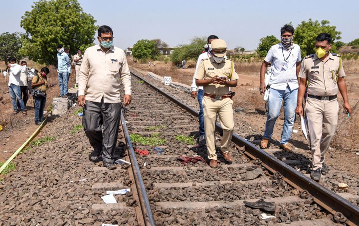 Police personnel along with officials walk on a rail track as they check the site following a train accident with migrant labourers sleeping on the railroad between Jalna and Aurangabad districts in Maharashtra state on May 8, 2020