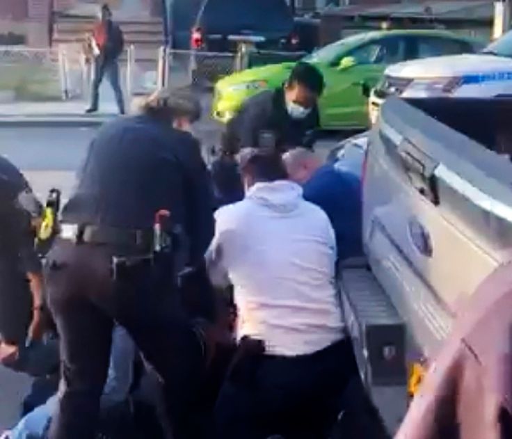 New York City police officers wrestle a man to the ground while making an arrest in the Brooklyn borough of New York on April 29.