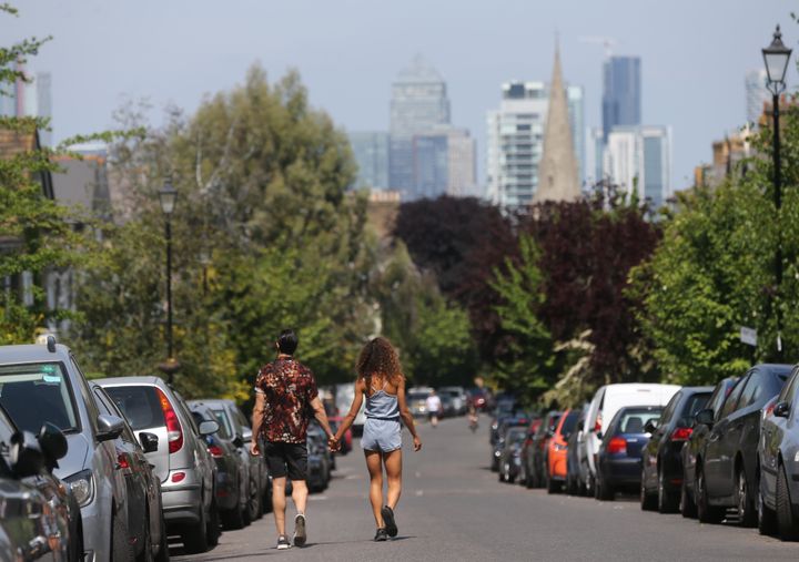A couple walk in the warm weather in Lewisham, south east London, as the UK continues in lockdown on Friday.